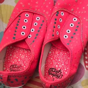 A pair of pink multi colored shoes no shoelaces :)